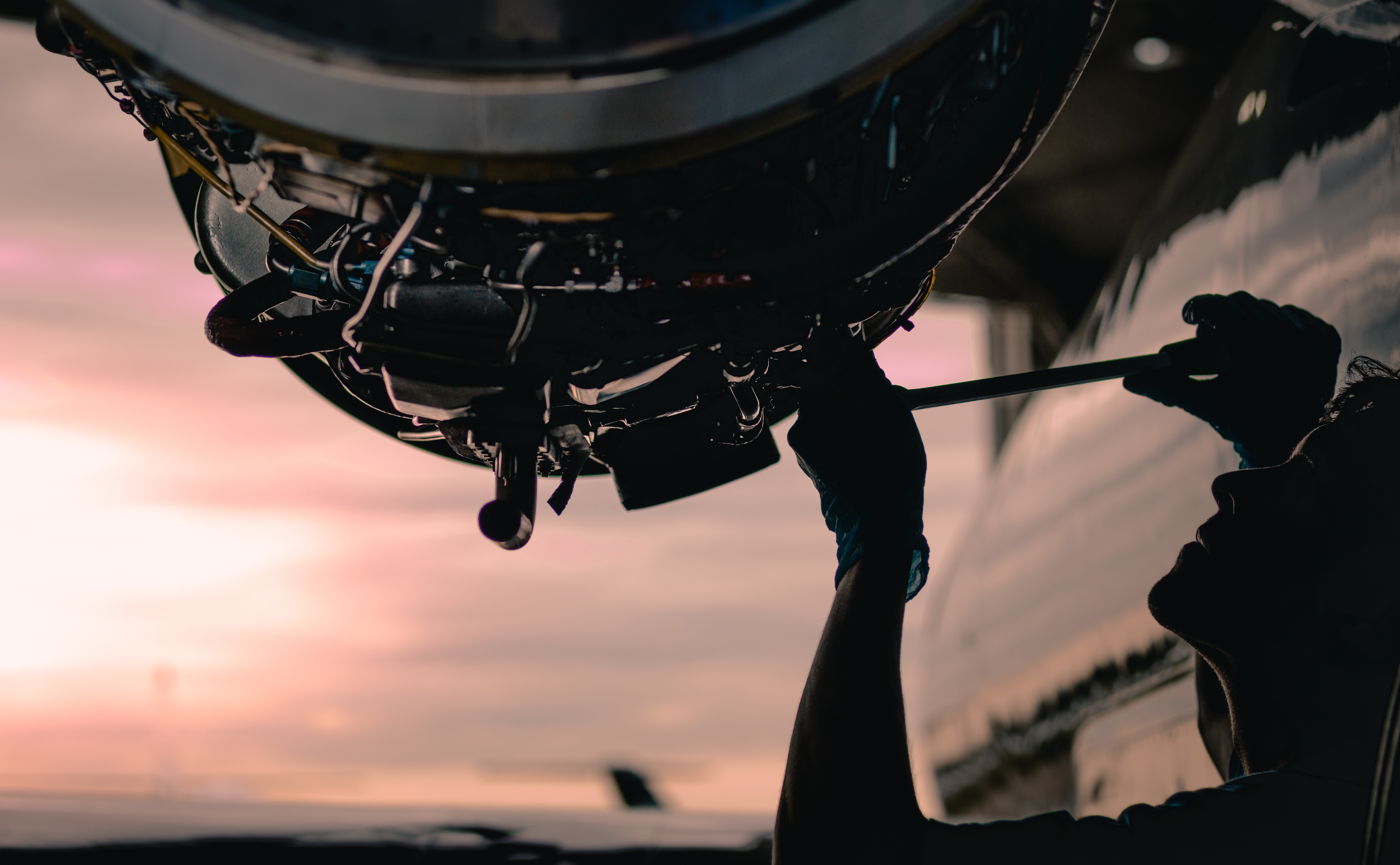 Técnico de Aviaser trabajando en un motor al atardecer